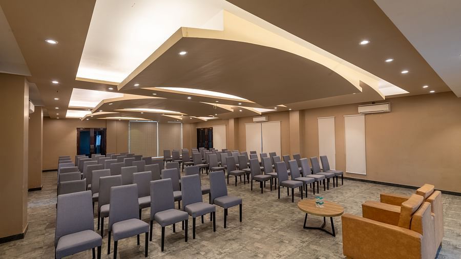 Banquet hall at DLS Forest Vines Resort, with cushioned seating arranged on both sides, a plush sofa, and a table placed in front.